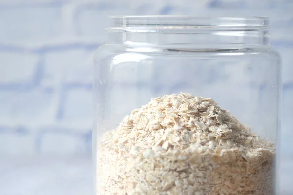Close up of oats flakes in a glass jar on table — Stock Photo, Image