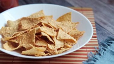 Masada bir kase cips ve salsa sosu. ,