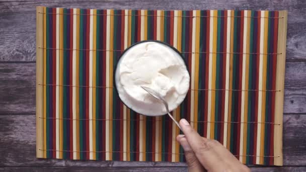 Κάτοψη του mans χέρι τρώει φρέσκο γιαούρτι από ένα μπολ — Αρχείο Βίντεο