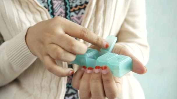 Женские руки, принимающие лекарства из ящика с таблетками — стоковое видео