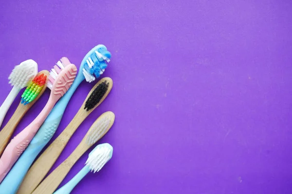 Colorful toothbrushes on purple background — Stock Photo, Image