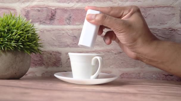 Young man putting artificial sweetener in tea, — Stock Video