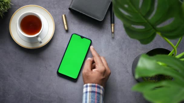 Vista superior de la mano del hombre utilizando el teléfono inteligente sobre fondo negro — Vídeos de Stock