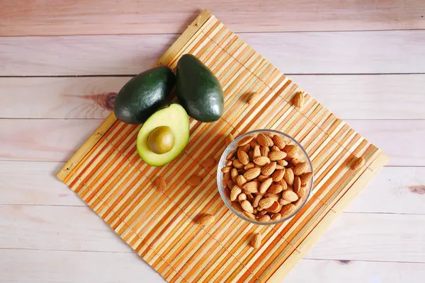 Ovanifrån av avokado och mandel nöt på bordet — Stockfoto