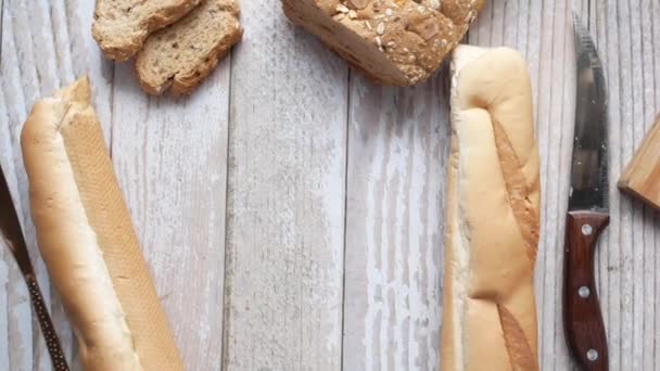 Kesme tahtasında tereyağı kesme ve arka planda kahverengi ekmek — Stok video