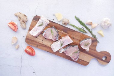 Yemek yapmaya hazırlanmak için doğrama tahtasındaki çiğ taze balık. ,