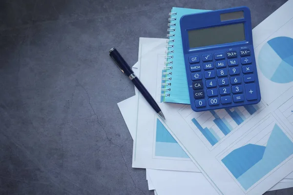 Pénzügyi grafikon, számológép és jegyzettömb fekete háttérrel — Stock Fotó