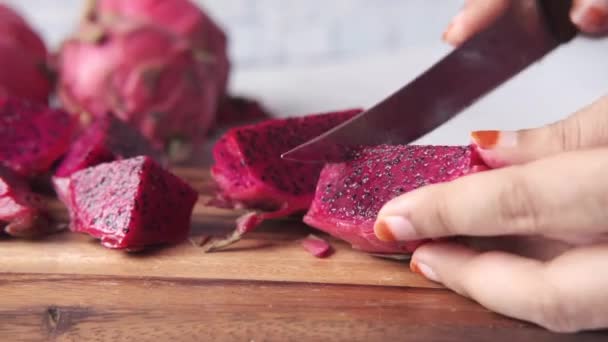 Jeune homme coupant un fruit dragon sur une planche à découper. — Video