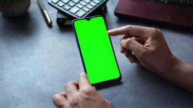  Ofis masasında akıllı telefon kullanan bir adamın dikiz görüntüsü 