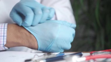 Doktor tıbbi lateks eldiven takıyor, yakın çekim.