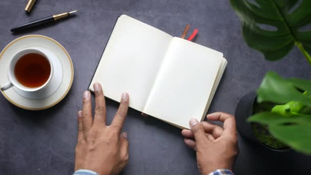 Vista superior de la mano del hombre girando un buscapersonas de un diario — Vídeos de Stock