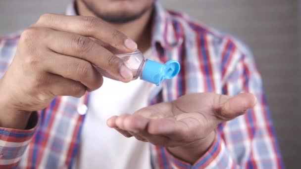 Молодой человек, использующий дезинфицирующую жидкость для предотвращения коронного вируса — стоковое видео