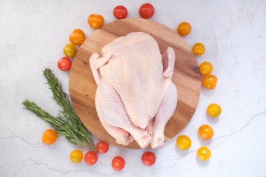  Beyaz arka planda çiğ tavuk ve kiraz domatesi. 