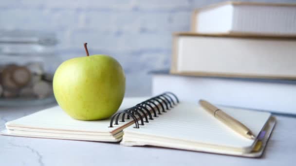 Concepto negro a la escuela con manzana en el bloc de notas en la mesa. — Vídeos de Stock