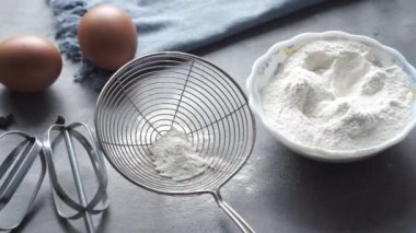 Siyah arkaplanda malzemeler pişiriliyor, üst görünüm.