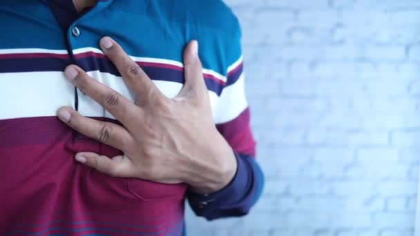 Young man suffering pain in heart and holding chest with hand — Stock Video