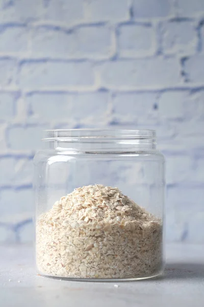 Primer plano de copos de avena en un frasco de vidrio en la mesa — Foto de Stock