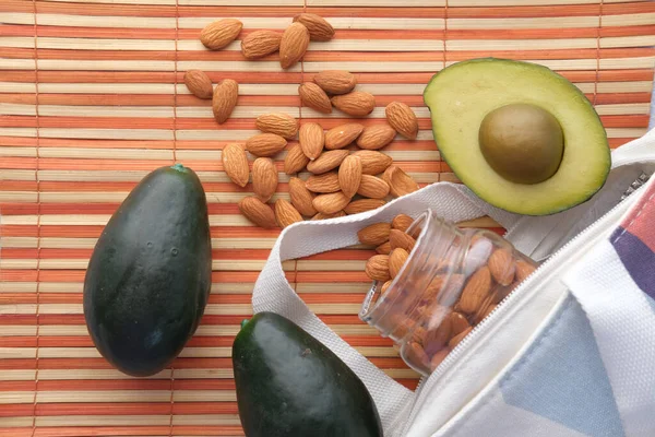 Närbild av skiva av avokado och mandelnöt på bordet — Stockfoto
