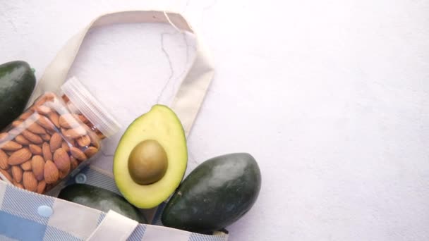 Nahaufnahme einer Scheibe Avocado und Mandelnuss auf dem Tisch — Stockvideo