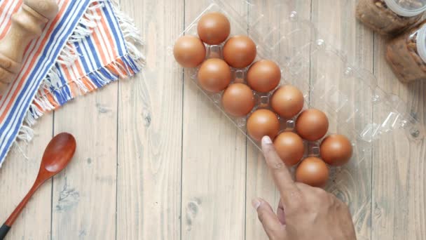 Bovenaanzicht van de mens met de hand plukken van een ei uit een plastic kast — Stockvideo