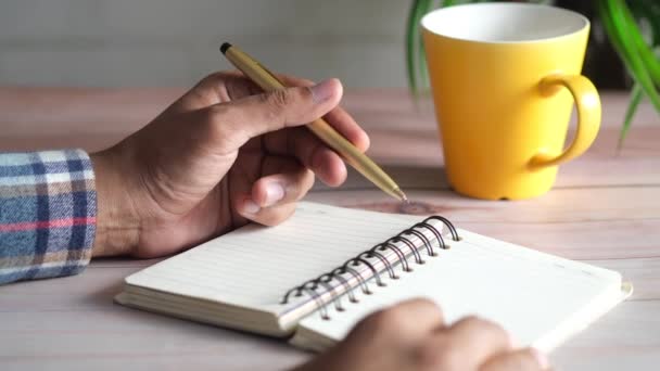 Zbliżenie człowiek ręka pisanie na notatnik. — Wideo stockowe