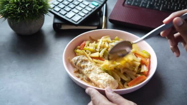 Joven comiendo comida saludable en el escritorio de la oficina — Vídeos de Stock