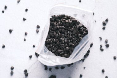 Plastik bir paketten çikolata parçaları dökülüyor.,