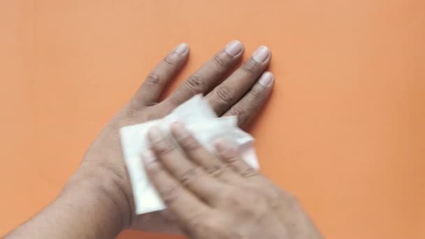 Man desinfecteert zijn handen met een natte veeg. — Stockvideo