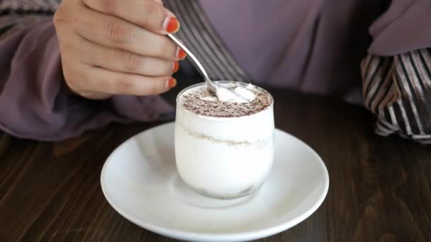 Женщины руки с ложкой едят мороженое на столике кафе — стоковое видео