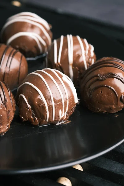 Rund form mörk choklad på en platta på rosa bakgrund — Stockfoto