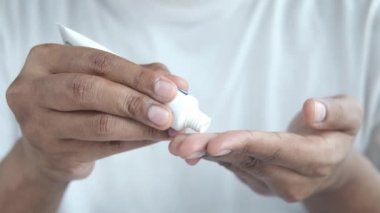 Antibiyotik kremi süren bir adam.
