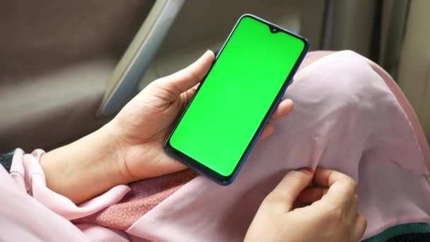 Mano de las mujeres sosteniendo el teléfono inteligente con pantalla verde en un coche — Vídeos de Stock