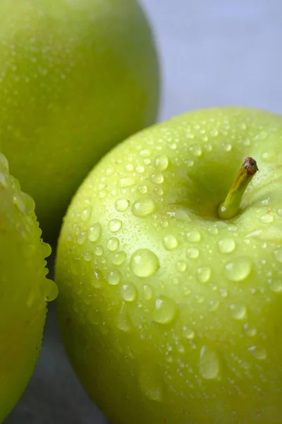 Närbild av färskt äpple med vattendroppe på bordet — Stockfoto