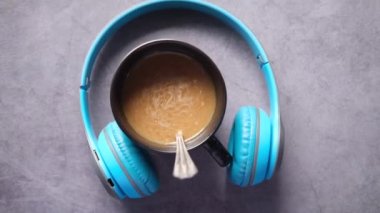 Siyah kahve fincanı ve masanın üstünde bir kafa telefonu. 