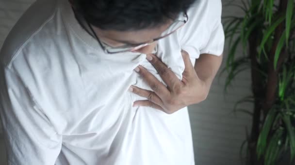 Young man suffering pain in heart and holding chest with hand — Stock Video