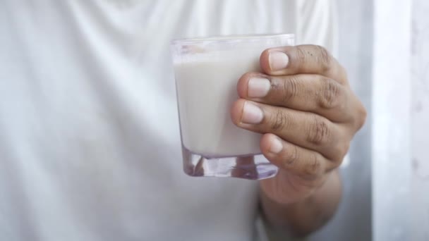 Uomo mano in possesso di un bicchiere di latte al mattino presto — Video Stock