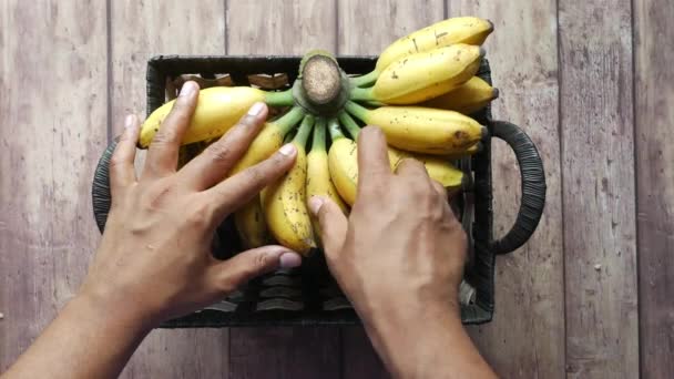 Mão pegar banana fresca em uma tigela na mesa . — Vídeo de Stock