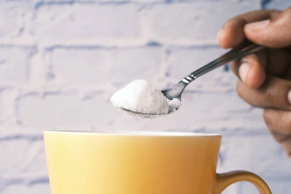 Verter azúcar blanco en una taza de té —  Fotos de Stock