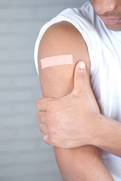 Adhesive bandage on young mans arm with copy space — Stock Photo, Image