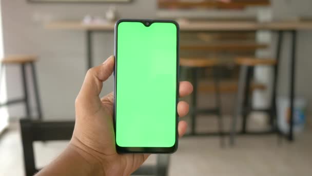 Primer plano de la mano del hombre joven utilizando el teléfono inteligente con pantalla verde — Vídeo de stock