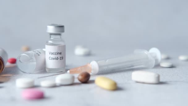 Close-up van het coronavirusvaccin, de medische pillen en de spuit op wit — Stockvideo