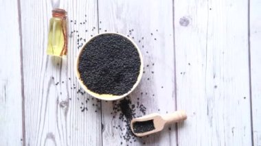 Masadaki kavanozda yağ olan küçük bir kap siyah kimyon..