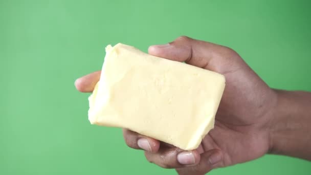 Hand houden boter tegen groene achtergrond — Stockvideo