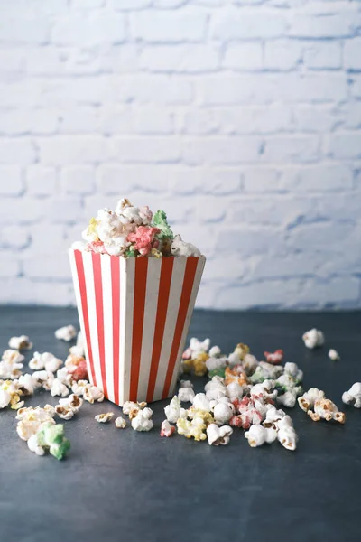 Palomitas de maíz derramadas de un recipiente sobre una mesa —  Fotos de Stock