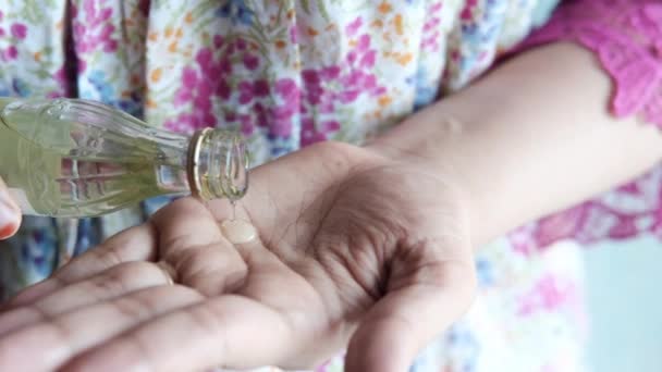 Jonge vrouwen gieten haar olie op de hand close-up — Stockvideo