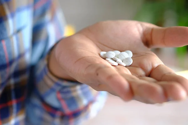 Primer plano de píldoras médicas blancas en la palma de la mano — Foto de Stock