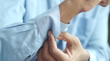 Adam gömleğini ilikliyor.