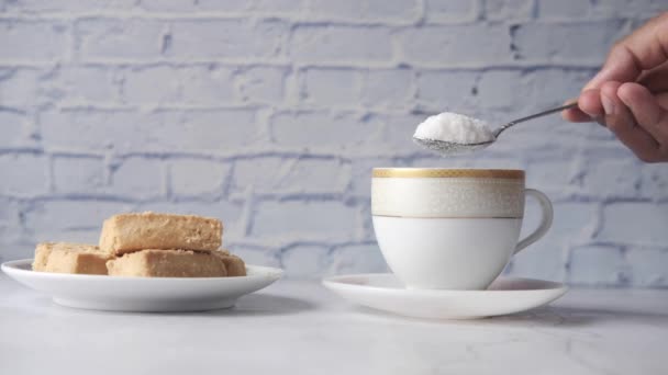 Наливая белый сахар в чашку чая — стоковое видео