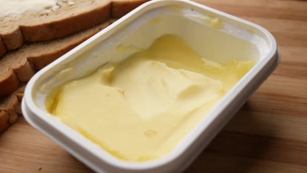 Scheibe Butter und Vollkornbrot auf Schneidebrett — Stockvideo