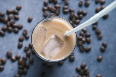 Siyah arka planda uzun bir bardakta buzlu kahve..